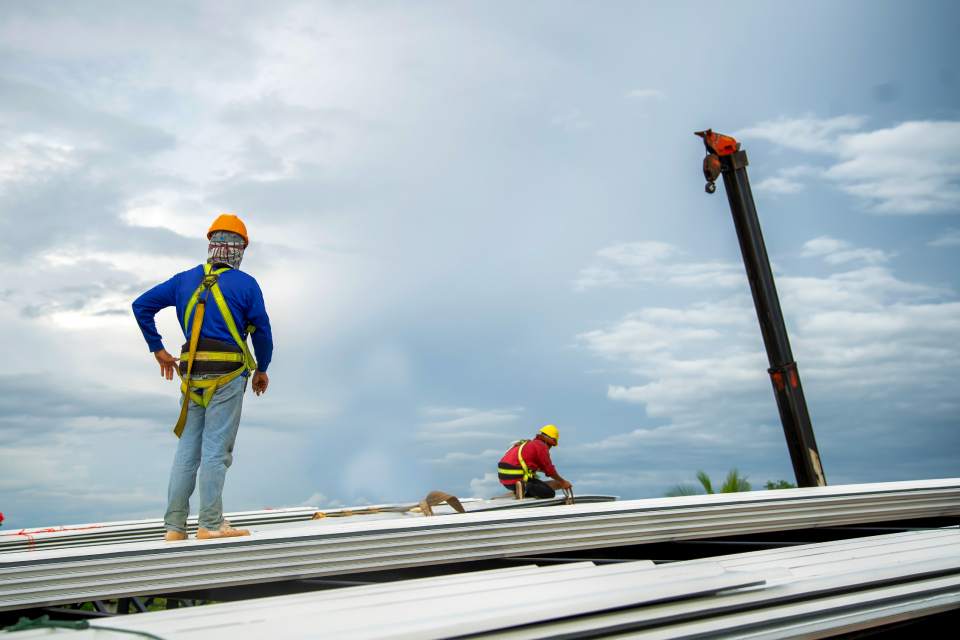 A team of construction workers repairing a commercial roof near Central Kentucky (KY).