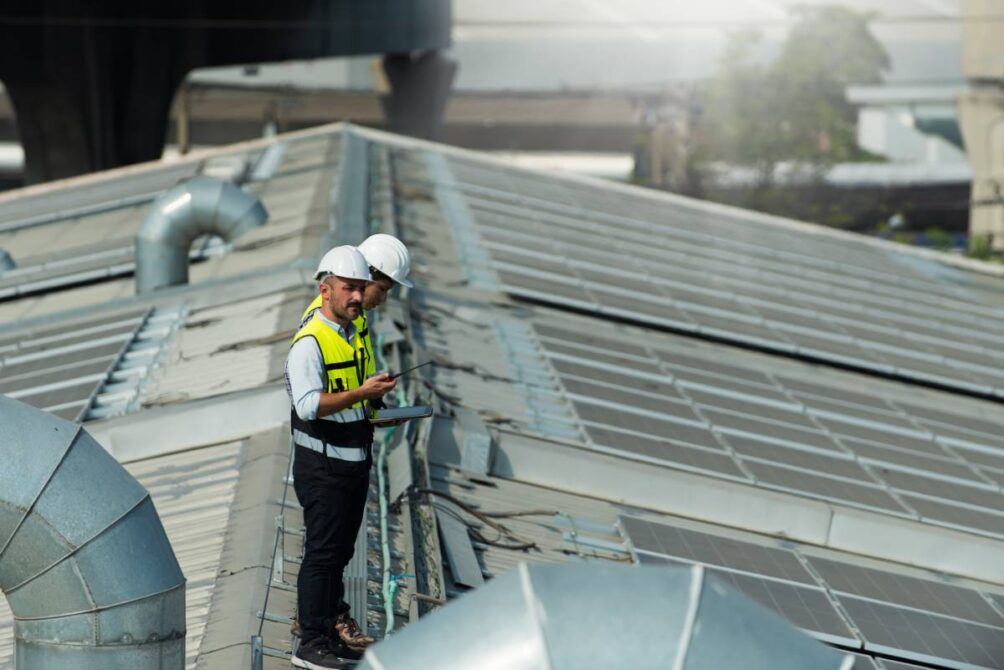 Two workers standing on an industrial roof at ABR Construction Inc near Nicholasville, KY