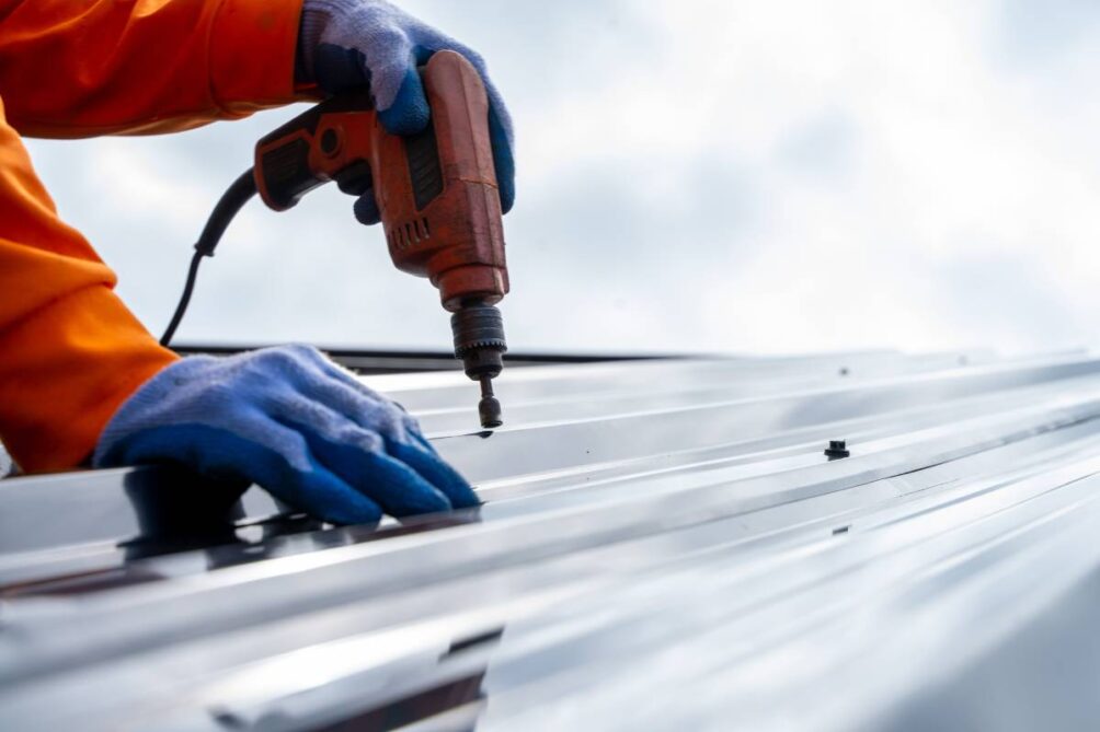Metal roof worker using a drill on a commercial roof at ABR Construction Inc. near Nicholasville, KY