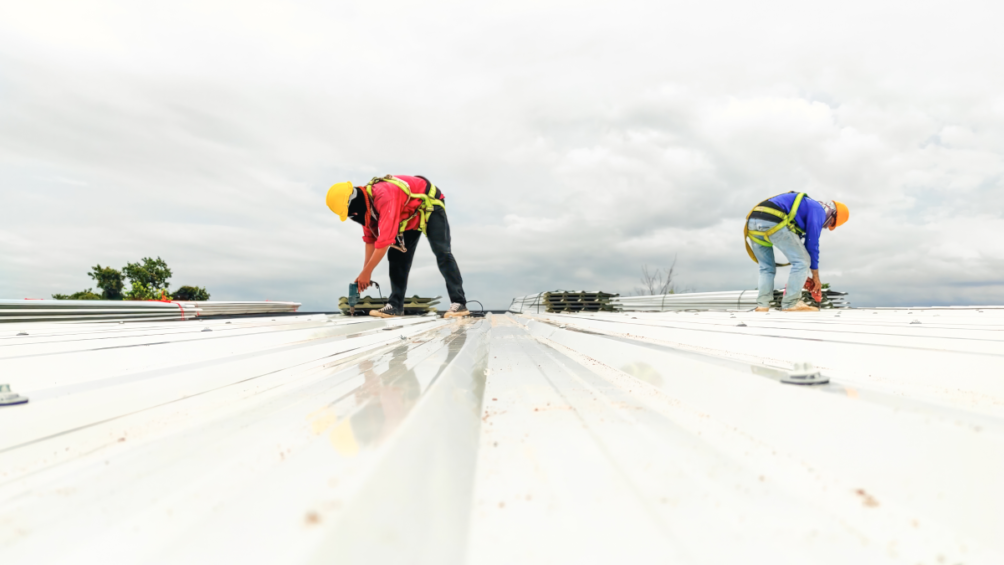 Two workers drilling into a commercial roof near Nicholasville, KY.