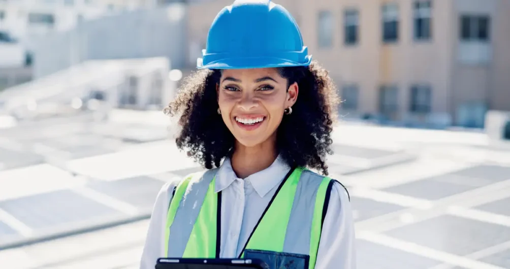 Commercial roofer in blue hardhat standing in front of an energy efficient roof.